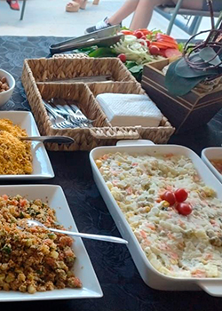 Mesa montada com pratos, talheres e acompanhamentos no Buffet de Churrasco Ouro