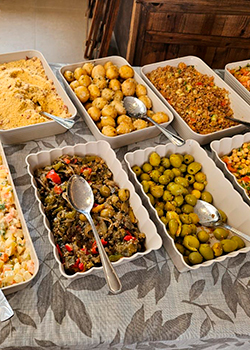 Mesa com saladas frescas, pães e pratos no Buffet de Churrasco Ouro