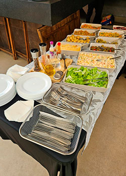 Mesa completa com saladas e acompanhamentos do Buffet de Feijoada em Domicílio