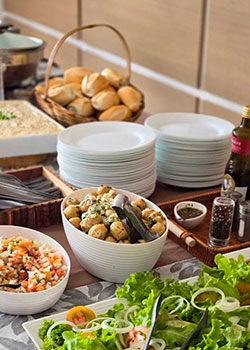 Mesa com saladas, pão francês e pratos organizados para o Buffet de Churrasco Prata em São Paulo